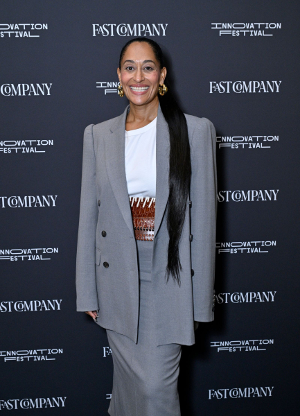 Tracee Ellis Ross posing in a gray skirt suit and long ponytail